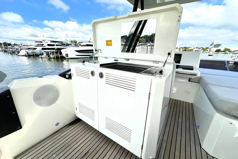 Lady Jane III Yacht Photos Pics Outdoor kitchen on 2023 Prestige 520 yacht, featuring grill and storage, docked at marina.