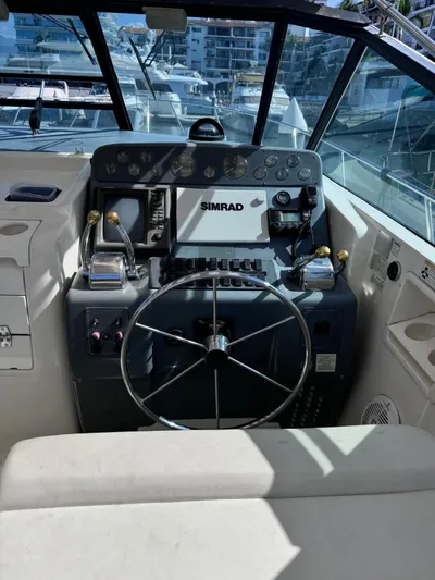 La Ultima Chica Yacht Photos Pics 1997 Tiara Yachts Express helm with steering wheel and navigation equipment.