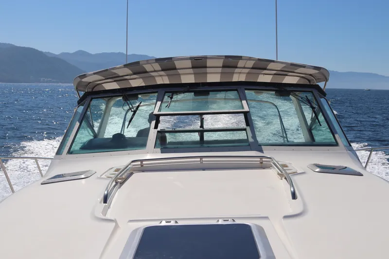 La Ultima Chica Yacht Photos Pics 1997 Tiara Yachts Express cruising on open water with scenic mountain backdrop.