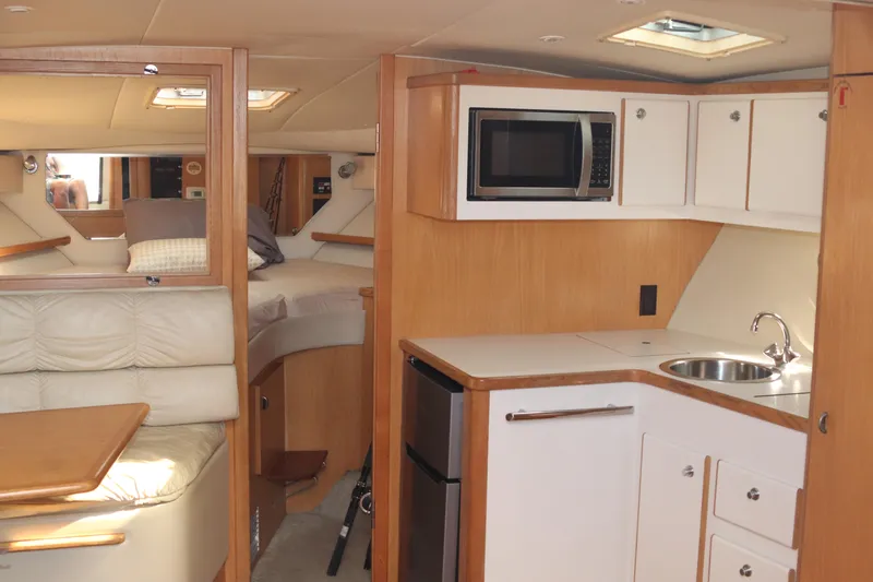 La Ultima Chica Yacht Photos Pics 1997 Tiara Yachts Express interior with kitchenette, microwave, and seating area.