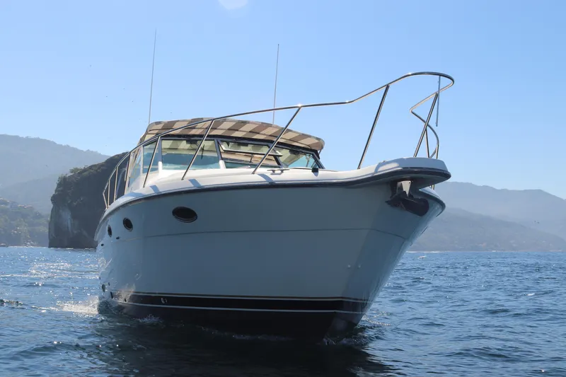 La Ultima Chica Yacht Photos Pics 1997 Tiara Yachts Express cruising on open water with scenic mountain backdrop.