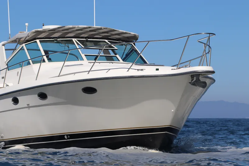 La Ultima Chica Yacht Photos Pics 1997 Tiara Yachts Express cruising on open water under clear blue sky.