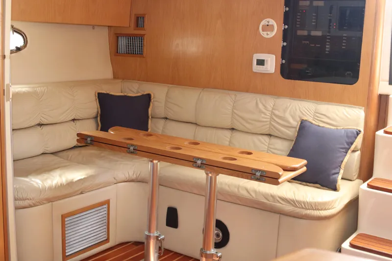 La Ultima Chica Yacht Photos Pics Interior of 1997 Tiara Yachts Express with beige seating and wooden table.