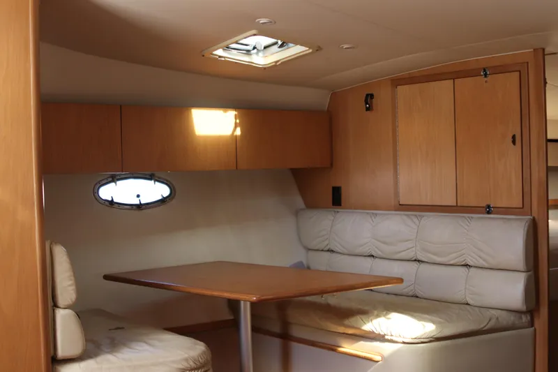 La Ultima Chica Yacht Photos Pics 1997 Tiara Yachts Express interior with wooden cabinets and cushioned seating area.