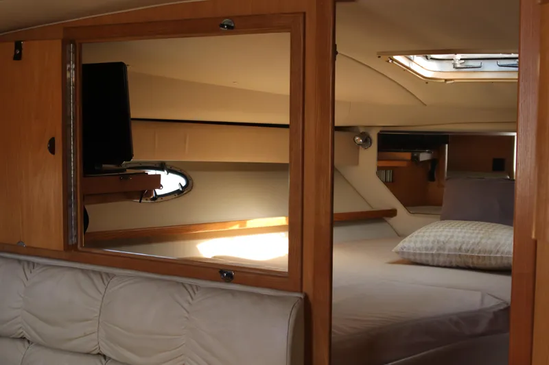 La Ultima Chica Yacht Photos Pics 1997 Tiara Yachts Express interior cabin with bed, mirror, and window.
