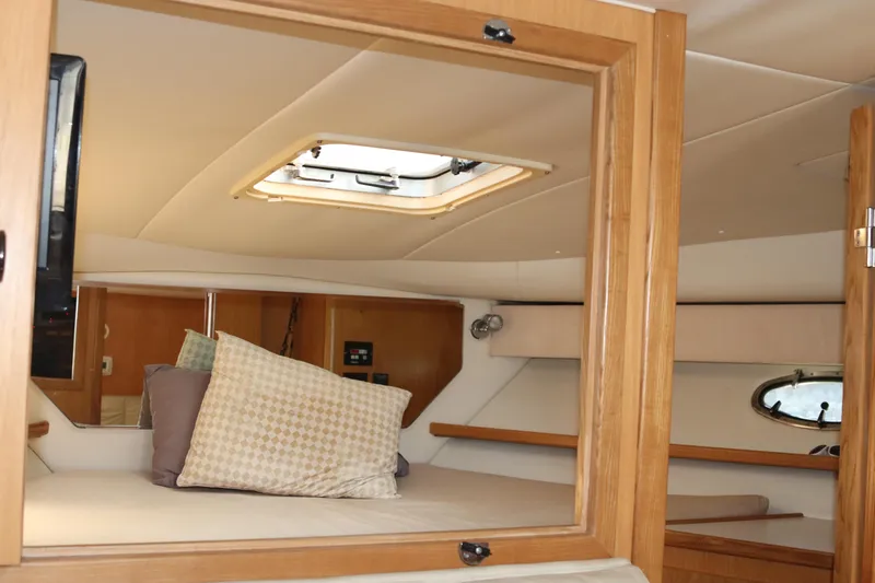 La Ultima Chica Yacht Photos Pics 1997 Tiara Yachts Express cabin interior with cozy bedding and wooden accents.
