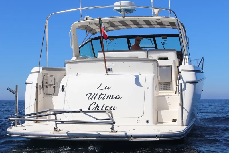 La Ultima Chica Yacht Photos Pics 1997 Tiara Yachts Express boat named "La Ultima Chica" on open water.
