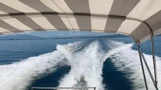 La Ultima Chica Yacht Photos Pics 1997 Tiara Yachts Express cruising on open water, view from under striped canopy.