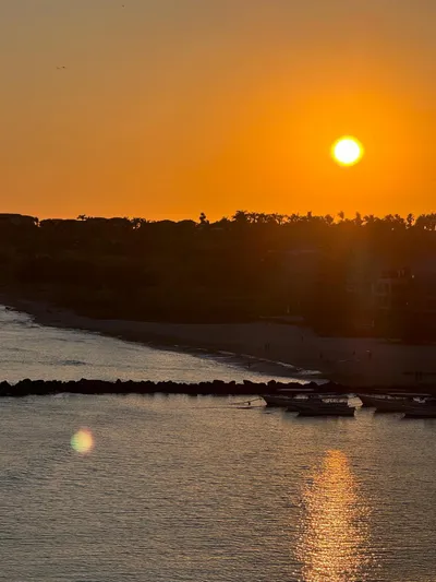 La Ultima Chica Yacht Photos Pics Sunset over a serene coastal scene with a 1997 Tiara Yachts Express.