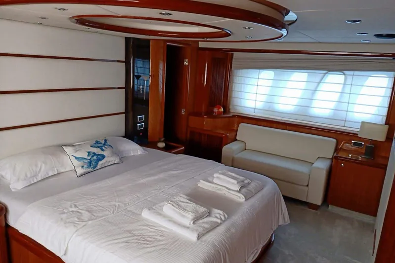  Yacht Photos Pics Luxurious bedroom interior of 2005 Sunseeker 94 Yacht with elegant wood finishes and cozy seating.