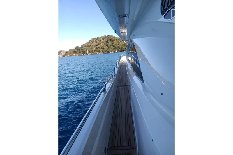  Yacht Photos Pics Side view of 2005 Sunseeker 94 Yacht cruising near a scenic coastline.