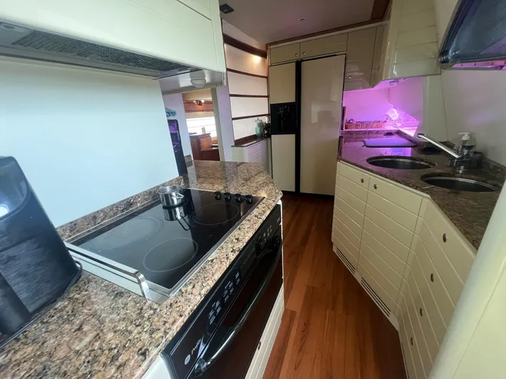 Etan Yacht Photos Pics Modern kitchen in a 2004 Ferretti Yachts 760 with granite countertops and wood flooring.