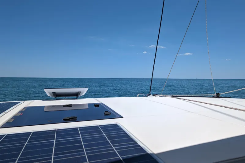 Changing Keys Yacht Photos Pics Leopard 40 catamaran deck with solar panels, sailing on a clear blue sea.