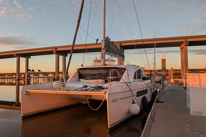 Changing Keys Yacht Photos Pics 2020 Leopard 40 catamaran docked at sunset, with bridge in background.