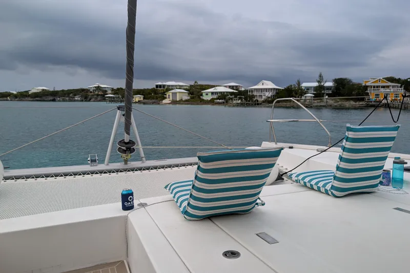 Changing Keys Yacht Photos Pics Leopard 40 catamaran deck with striped cushions, overlooking calm waters and coastal homes.