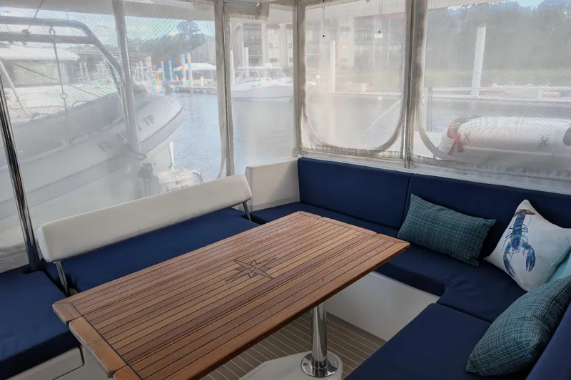 Changing Keys Yacht Photos Pics Leopard 40 catamaran interior with wooden table and blue cushioned seating, 2020 model.