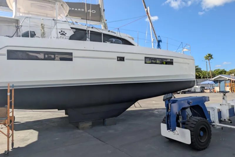 Changing Keys Yacht Photos Pics 2020 Leopard 40 catamaran on dry dock, with blue sky and palm trees in the background.