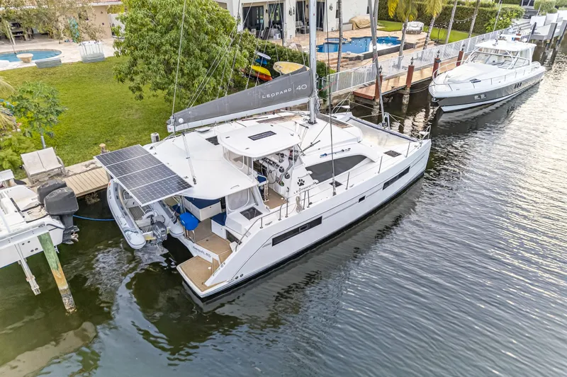 Changing Keys Yacht Photos Pics 2020 Leopard 40 catamaran docked by waterfront property with solar panels.