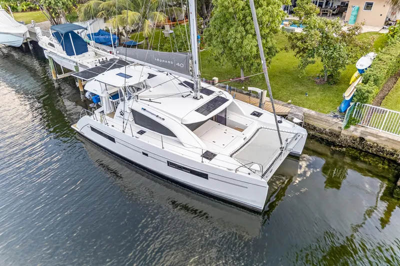 Changing Keys Yacht Photos Pics Aerial view of a 2020 Leopard 40 catamaran docked by lush greenery.