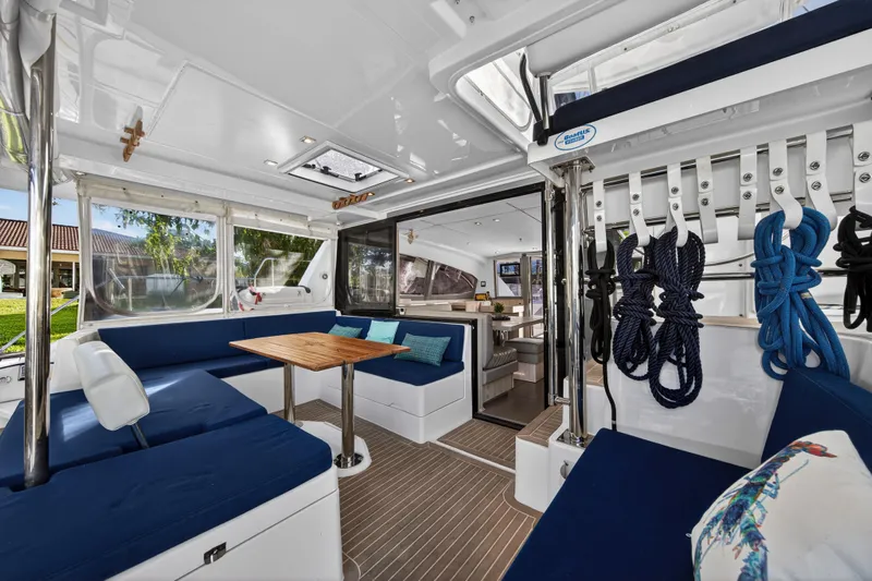 Changing Keys Yacht Photos Pics Luxurious 2020 Leopard 40 catamaran interior with blue seating, wooden table, and nautical decor.