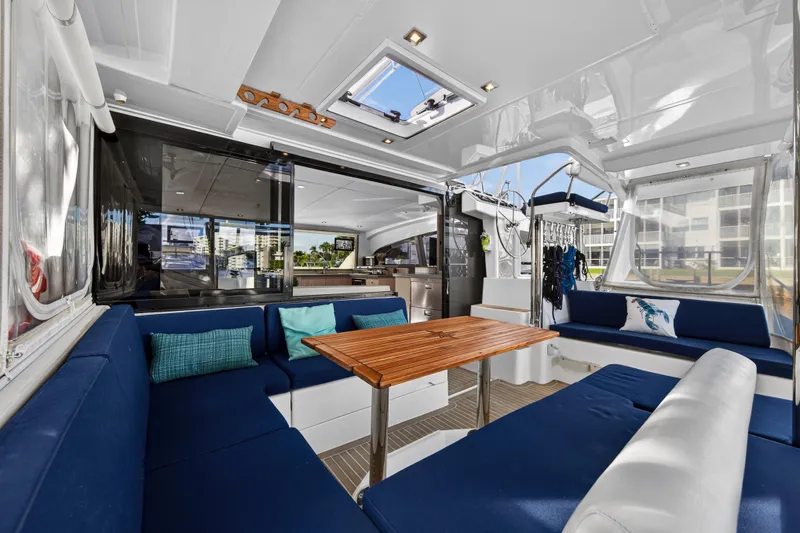 Changing Keys Yacht Photos Pics Luxurious interior of 2020 Leopard 40 catamaran with blue seating and wooden table.