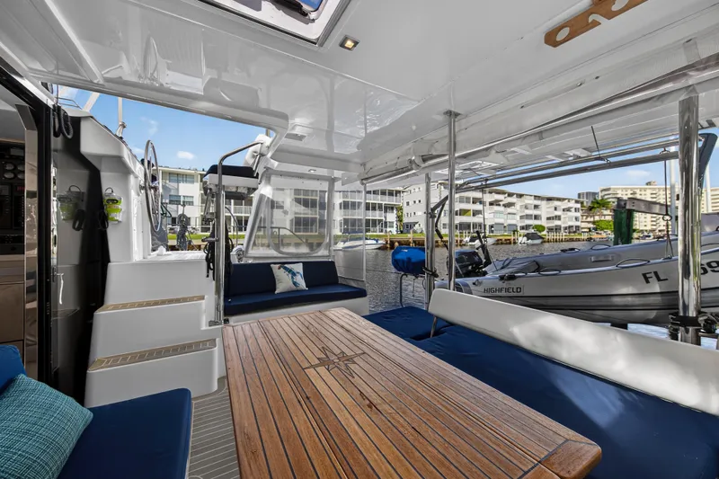 Changing Keys Yacht Photos Pics Spacious deck of 2020 Leopard 40 catamaran with wooden table and marina view.