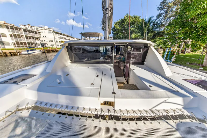 Changing Keys Yacht Photos Pics 2020 Leopard 40 catamaran docked near waterfront buildings and lush greenery.