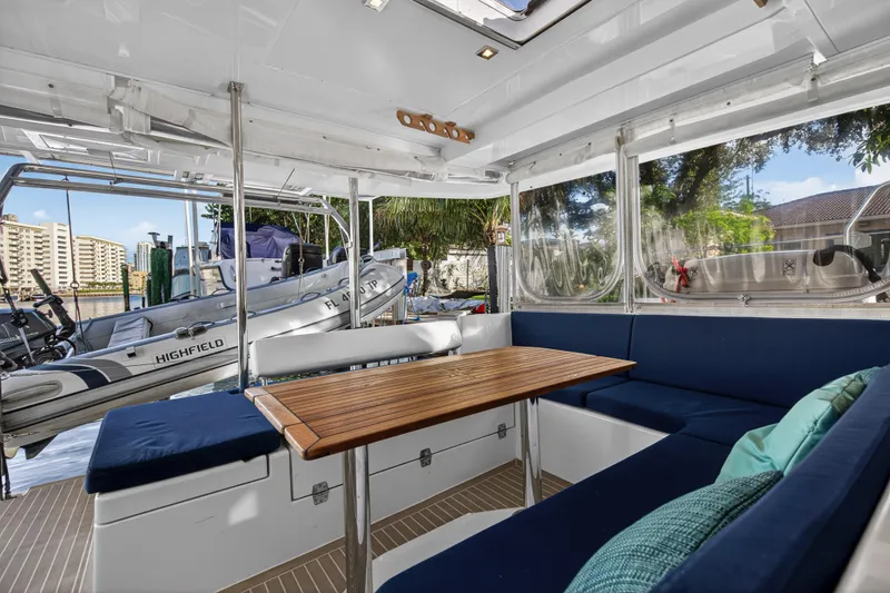 Changing Keys Yacht Photos Pics Interior of 2020 Leopard 40 catamaran with blue seating and wooden table, docked near water.