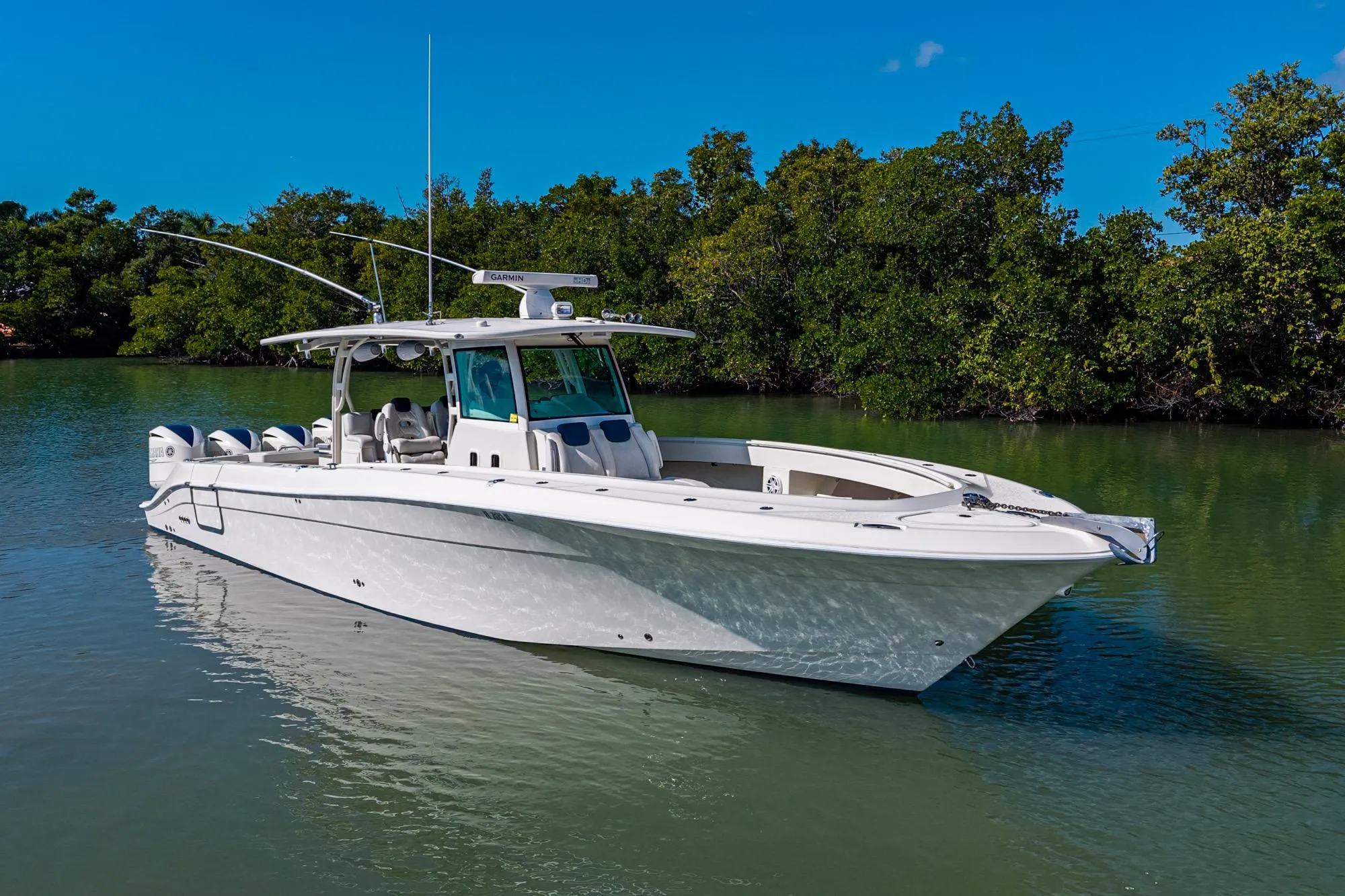 2018 HCB 42 Siesta boat on calm water, surrounded by lush greenery.