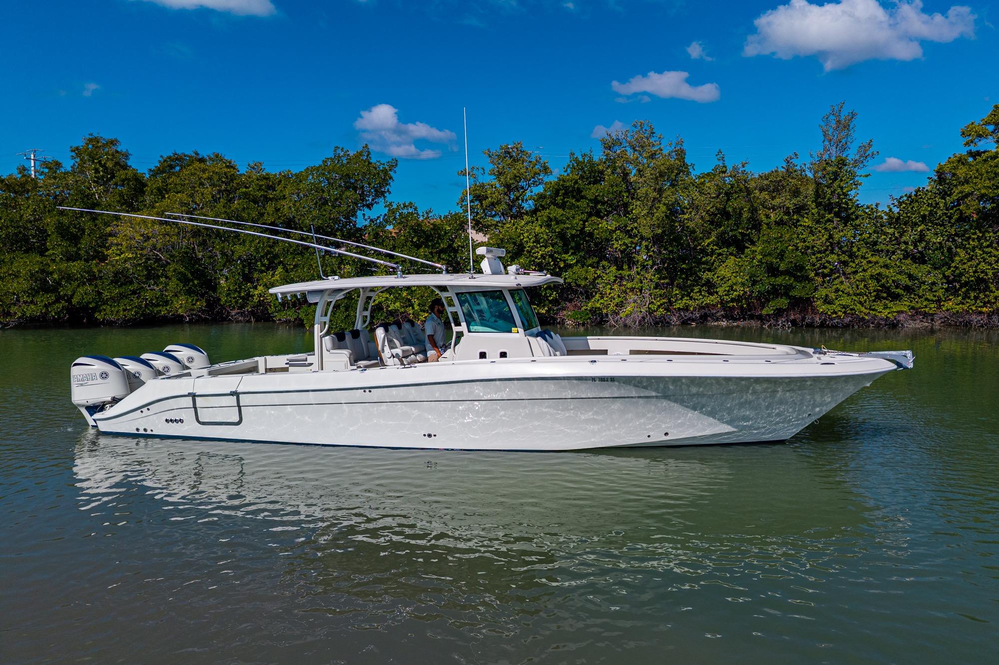 2018 HCB 42 Siesta boat on calm water, surrounded by lush greenery.