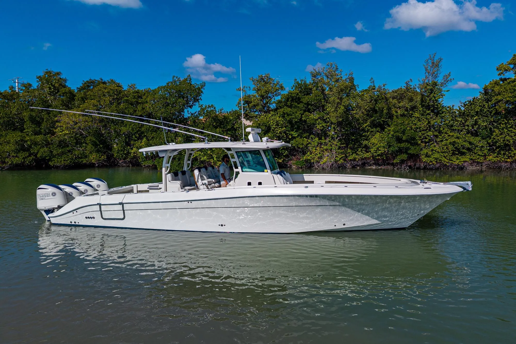2018 HCB 42 Siesta boat on calm water, surrounded by lush greenery.