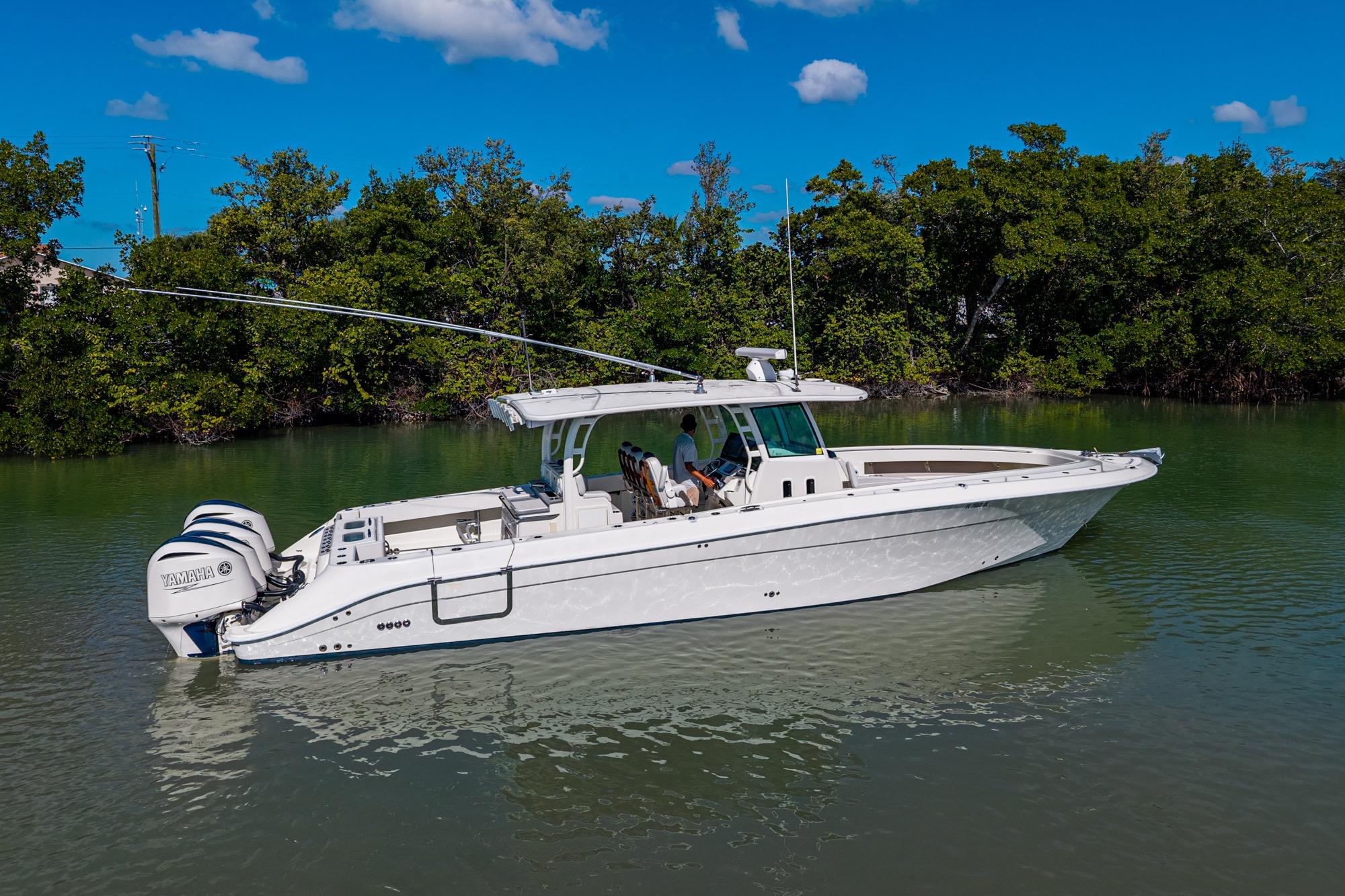 2018 HCB 42 Siesta boat on calm water with lush green trees in the background.