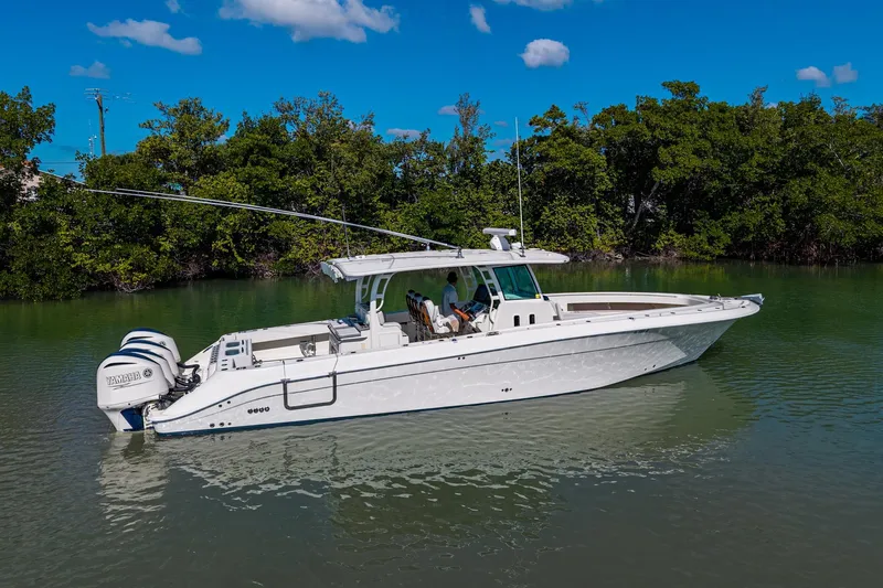  Yacht Photos Pics 2018 HCB 42 Siesta boat on calm water with lush green trees in the background.