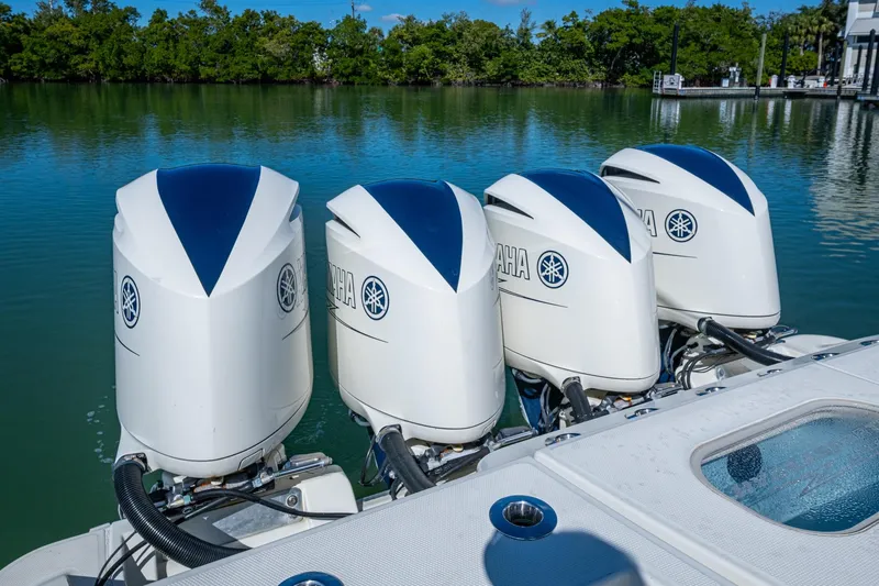  Yacht Photos Pics Four Yamaha outboard engines on a 2018 HCB 42 Siesta boat, docked by a serene lake.