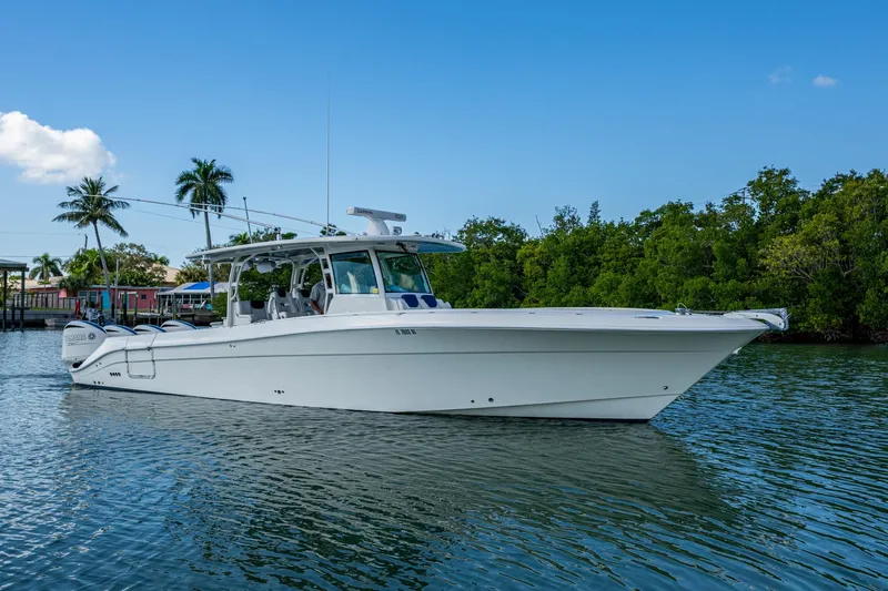  Yacht Photos Pics 2018 HCB 42 Siesta boat on calm water with lush greenery and blue sky.