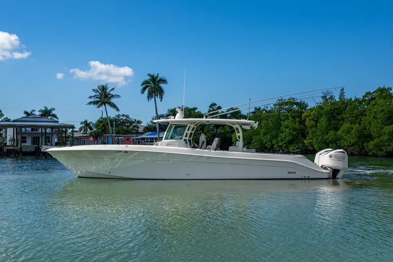 Yacht Photos Pics 2018 HCB 42 Siesta boat on calm water, surrounded by palm trees and clear blue sky.