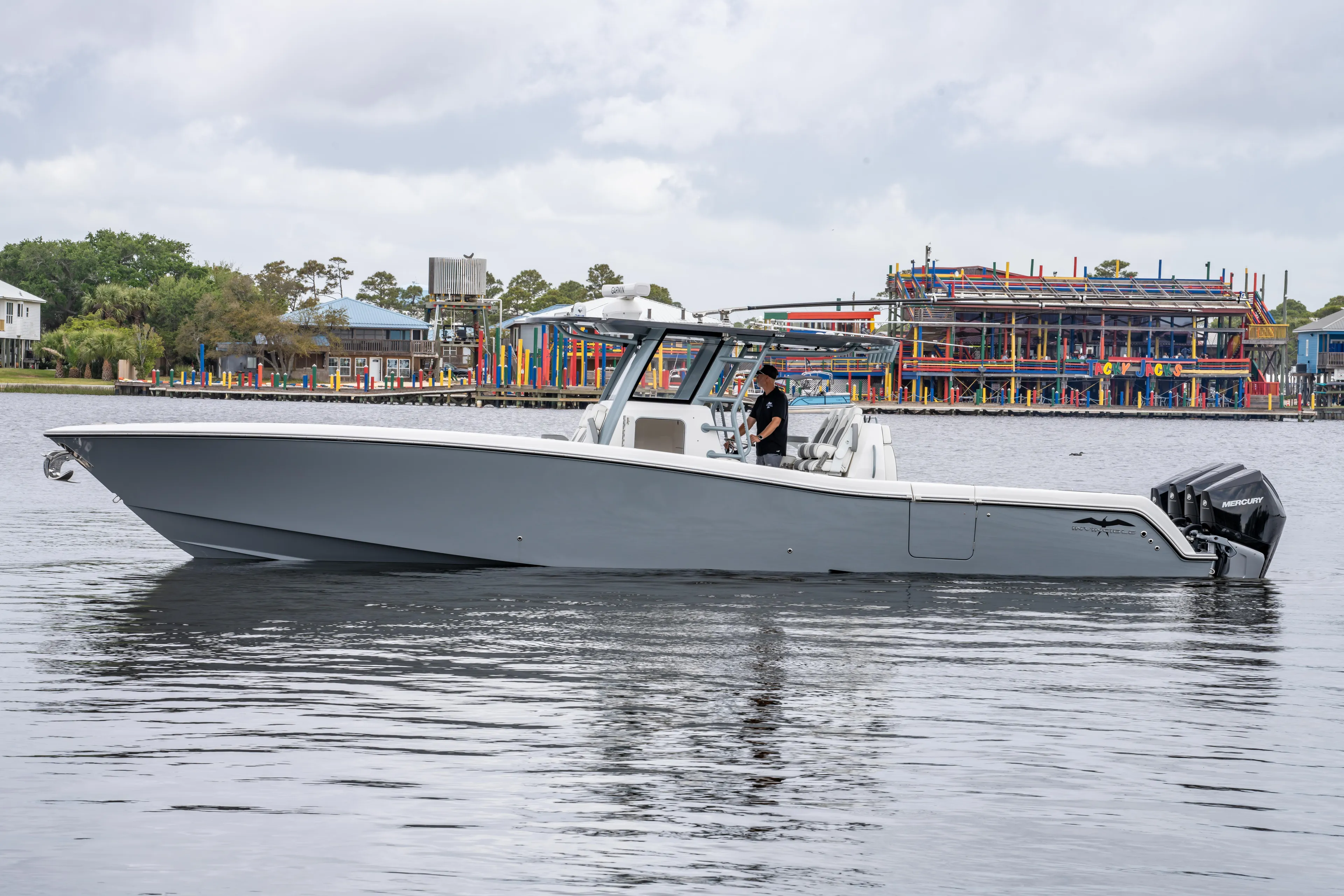  Yacht Photos Pics 2022 Invincible 39 Open Fisherman boat on calm water near colorful waterfront buildings.