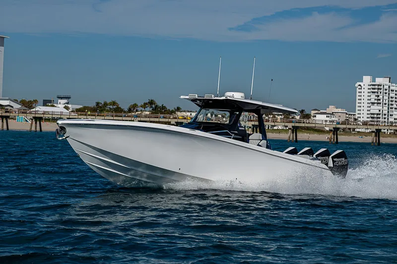  Yacht Photos Pics 2023 Nor-Tech 400 boat cruising on open water near a coastal city.