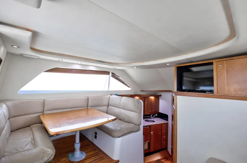  Yacht Photos Pics Luxurious interior of 2003 Jupiter 35 Flybridge yacht with dining area and kitchenette.