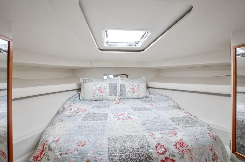  Yacht Photos Pics Cozy cabin interior of 2003 Jupiter 35 Flybridge with patterned bedding.