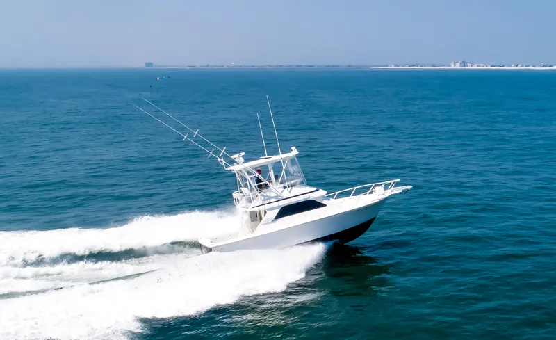  Yacht Photos Pics Jupiter 35 Flybridge 2003 cruising on open sea, creating a dynamic wake.