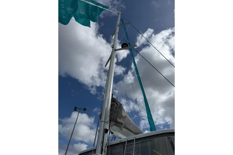  Yacht Photos Pics Sailboat mast of 2026 Lagoon 55 against a cloudy sky.