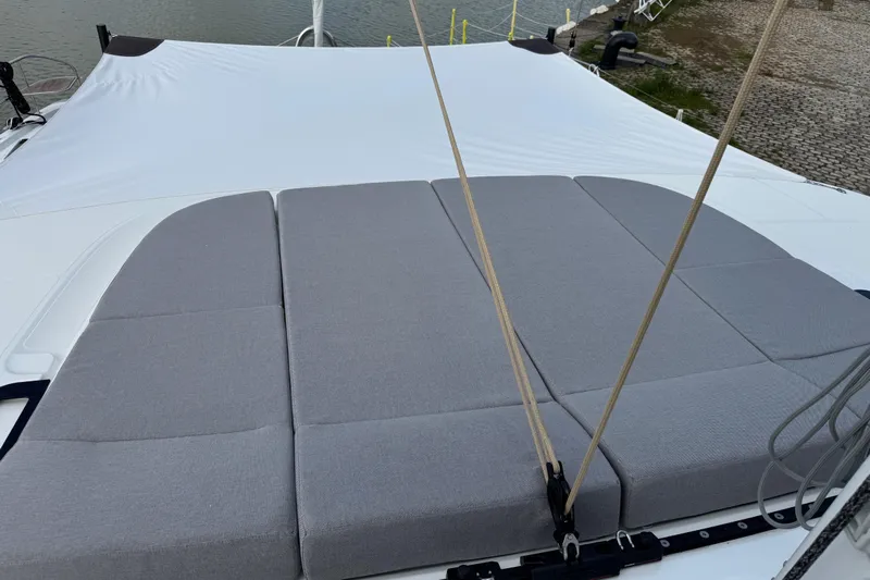  Yacht Photos Pics Sunbathing area on 2026 Lagoon 55 yacht with gray cushions and white cover.