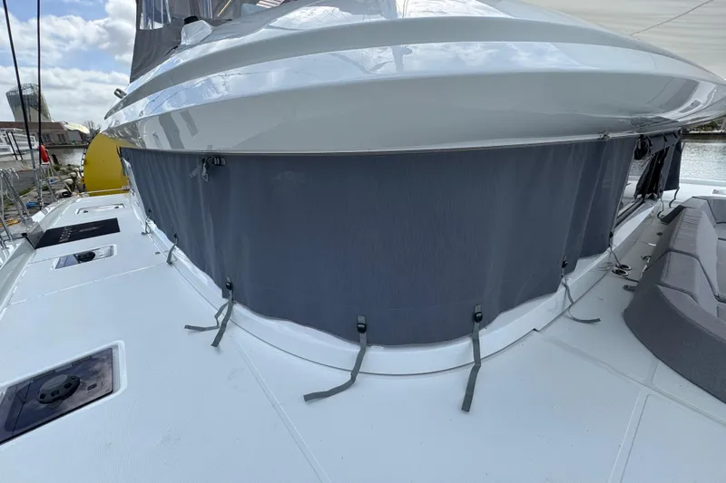  Yacht Photos Pics 2026 Lagoon 55 yacht deck with gray canvas cover and seating area.