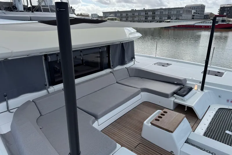 Yacht Photos Pics Luxurious Lagoon 55 yacht deck with modern seating, 2026 model, docked by waterfront.