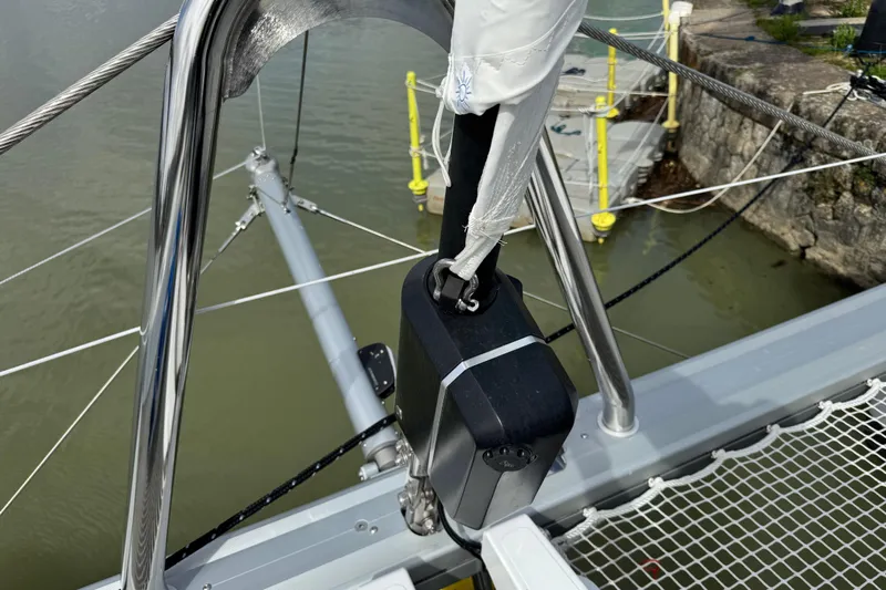  Yacht Photos Pics Close-up of Lagoon 55 sailboat rigging and netting, docked by a stone pier, 2026 model.