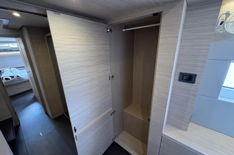  Yacht Photos Pics Modern interior of 2026 Lagoon 55 yacht with open wooden closet.