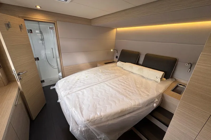  Yacht Photos Pics Luxurious bedroom interior of 2026 Lagoon 55 yacht with modern design and ambient lighting.