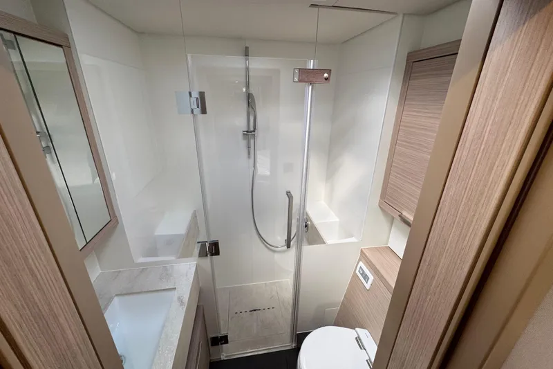  Yacht Photos Pics Modern bathroom in 2026 Lagoon 55 yacht with glass shower and sleek fixtures.