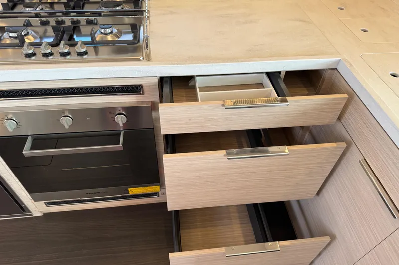  Yacht Photos Pics Modern kitchen with open drawers and stainless steel stove in Lagoon 55 yacht, 2026 model.